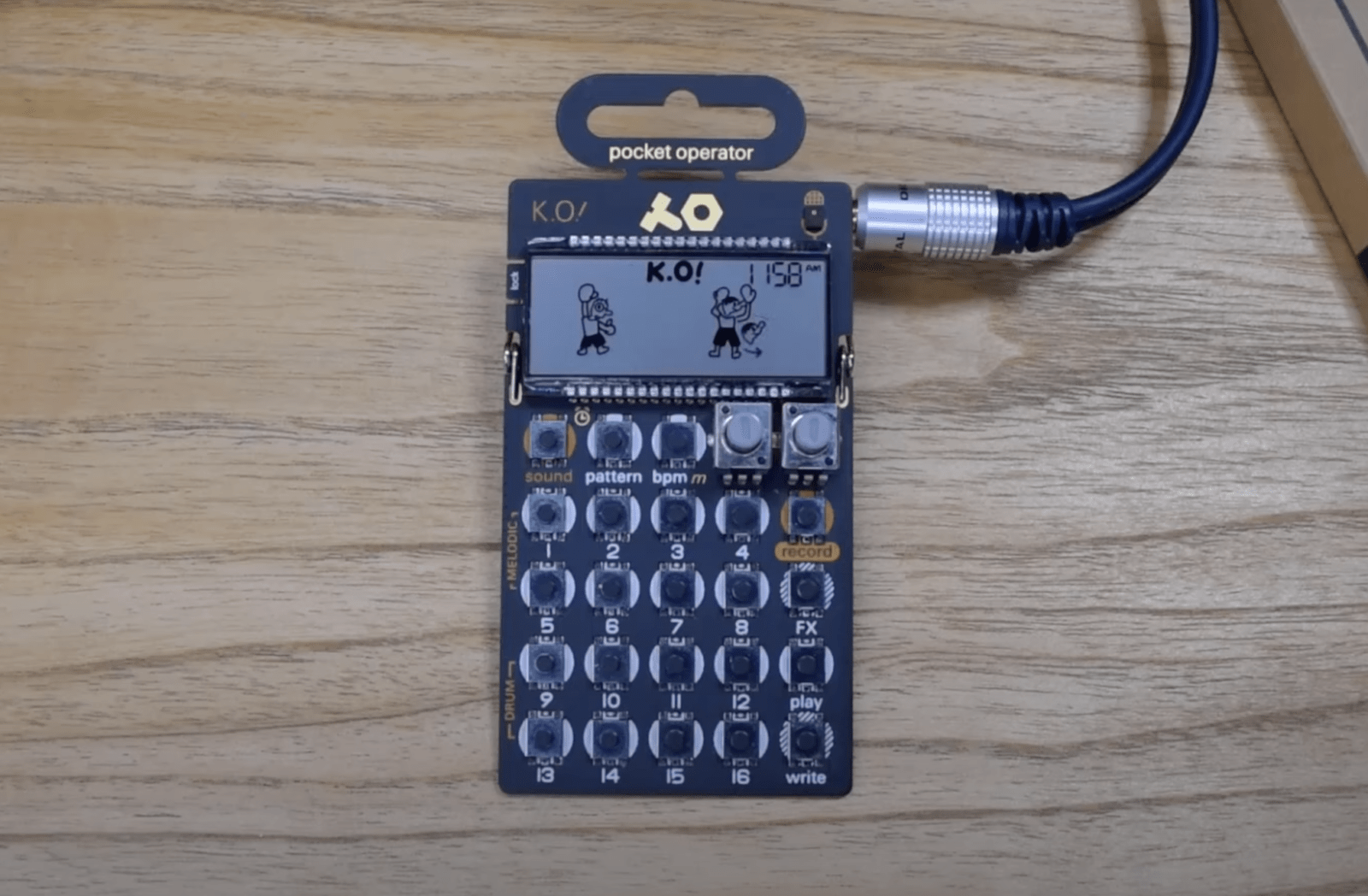 La fotografía muestra un POCKET OPERATOR PO-33 K.O! funcionando, con pixel art en su pantalla